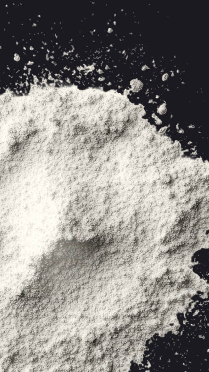 Close-up of a pile of white powder against a black background